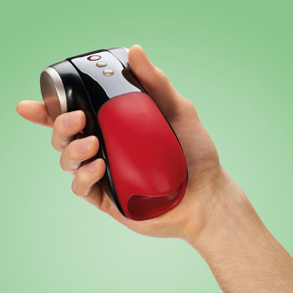 A hand holds a black and red vibrating penis masturbator.