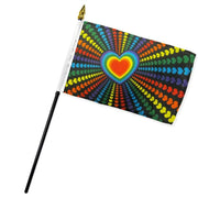 A rainbow heart flag on a stick with radiating hearts.