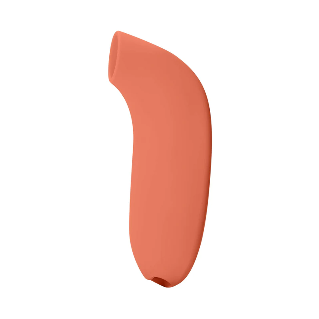 Papaya colored silicone clitoral stimulator with a curved shape.