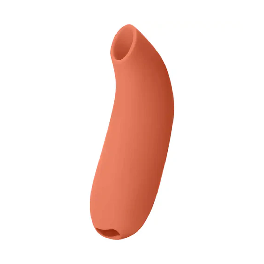 Papaya colored silicone clitoral stimulator with a curved shape.