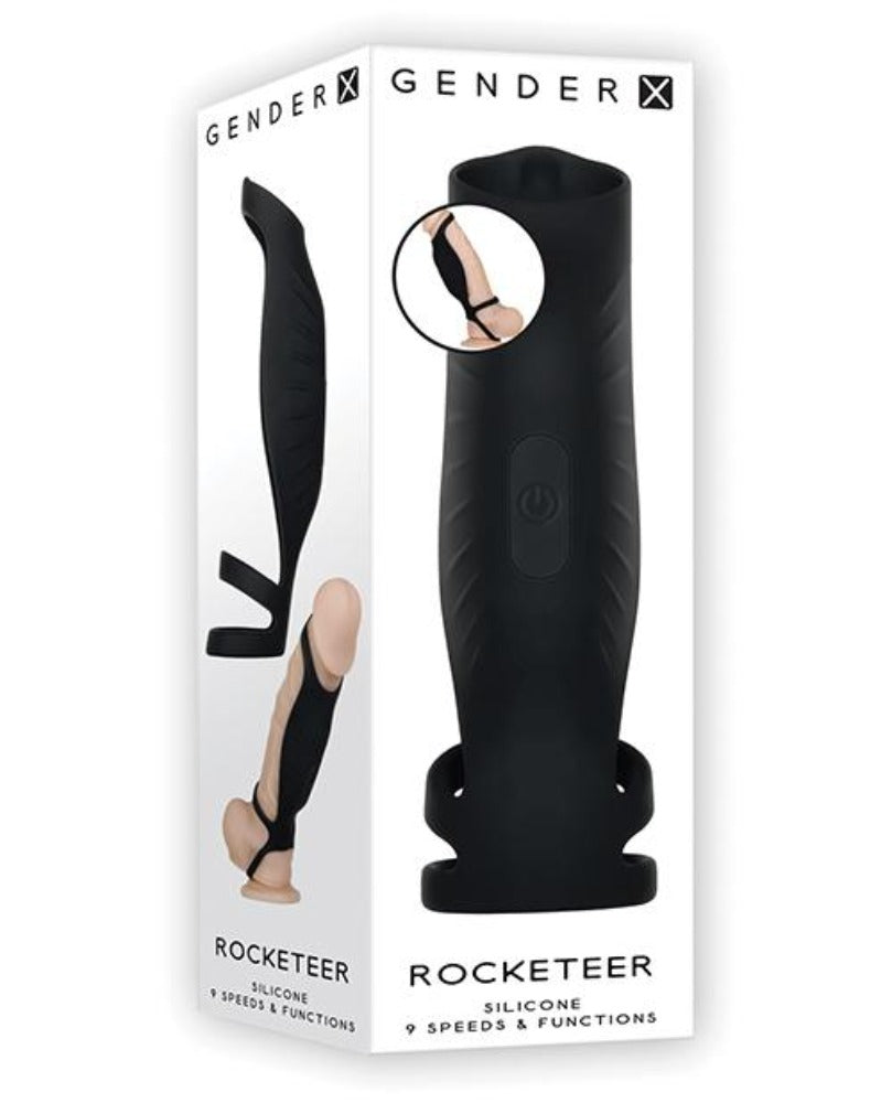 Black silicone cock sheath with a vibrating insert and straps, on a white box.