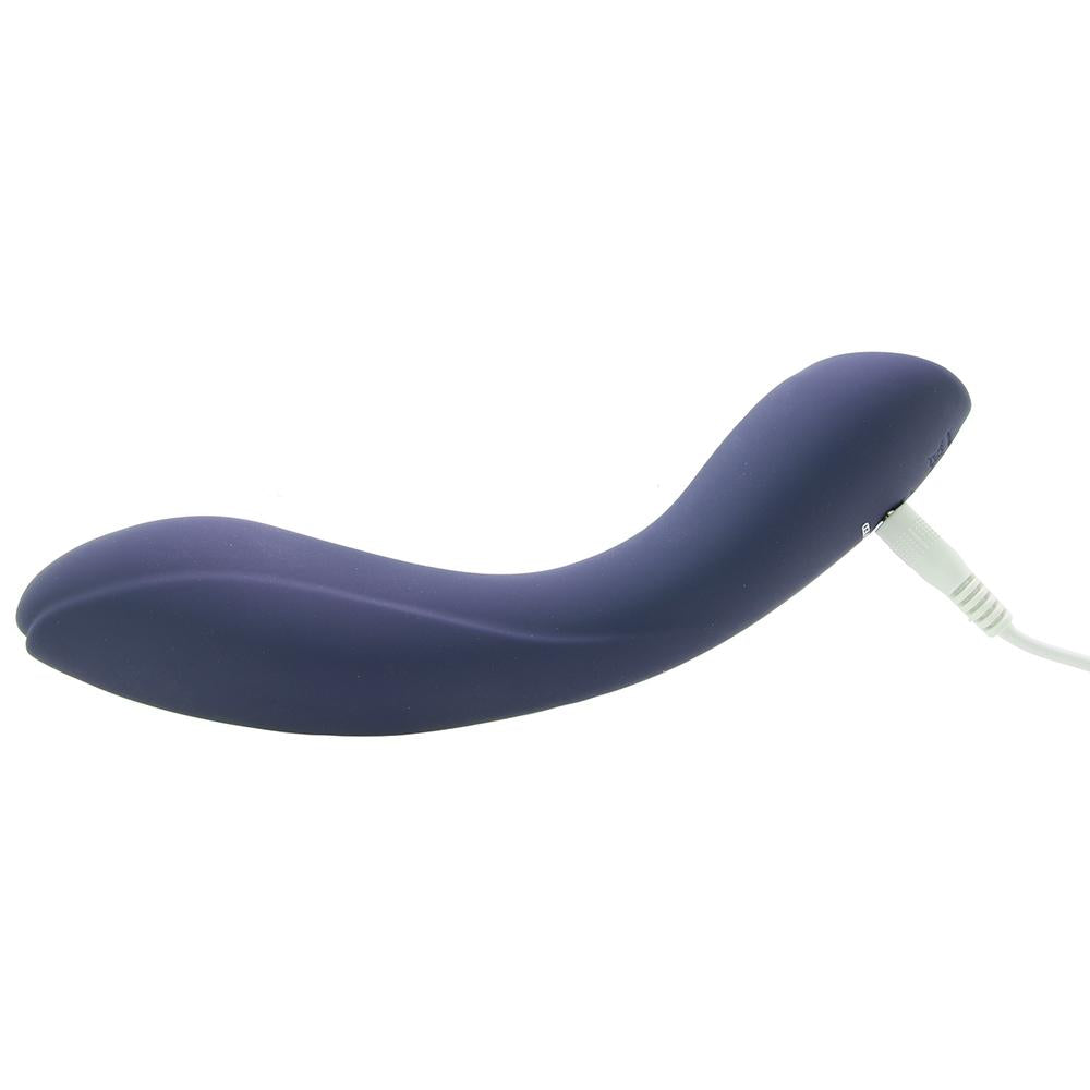 A curved purple silicone vibrator with a white charging cable.