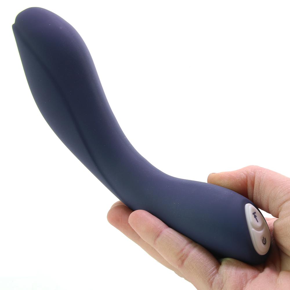 A curved, dark blue silicone vibrator held in a hand, with power and mode buttons visible.