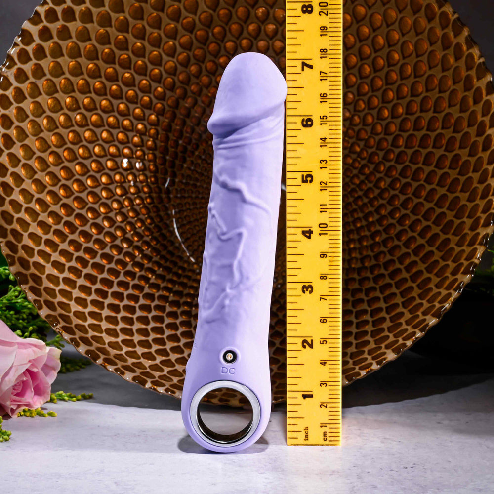 Purple rechargeable silicone vibrator with realistic texture, handle, and measuring tape.