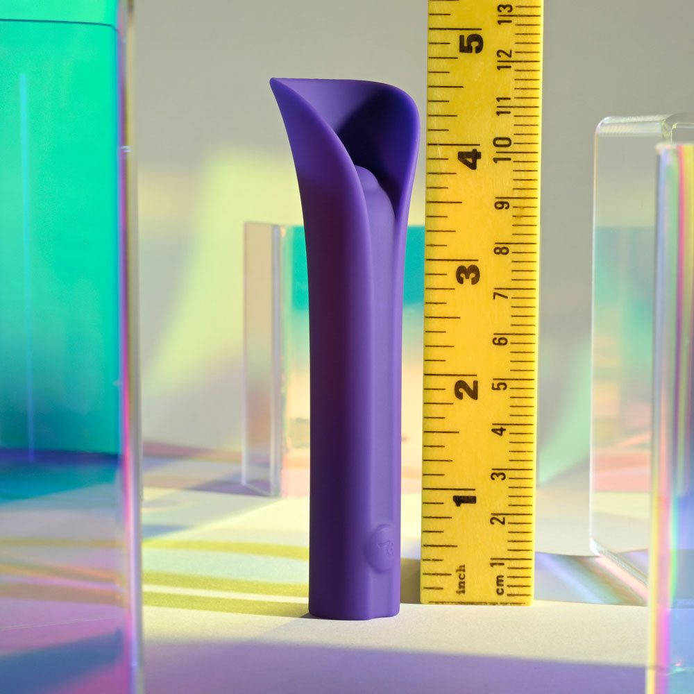 A purple silicone vibrating bullet is measured against a ruler.