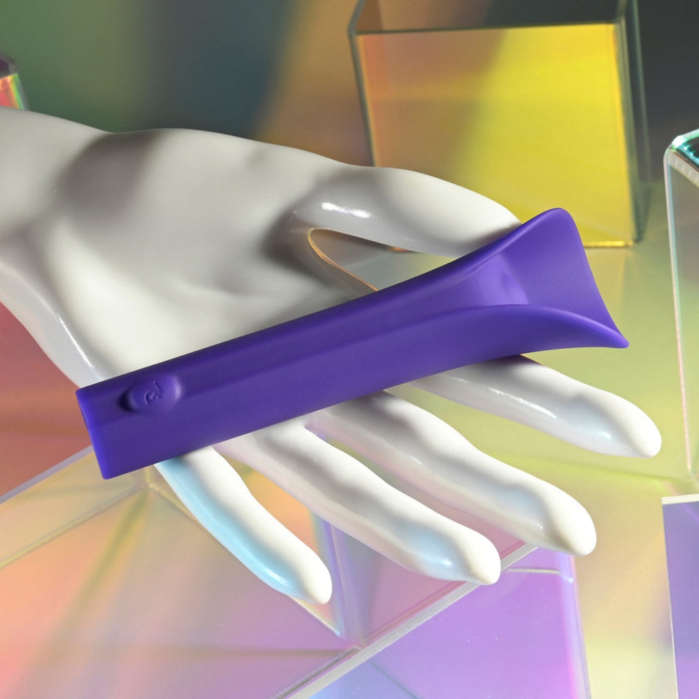 Purple silicone vibrating bullet held on a white mannequin hand.