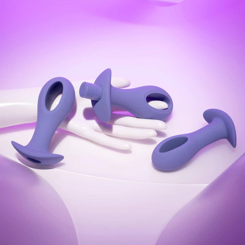 Three purple silicone anal plugs with hollow centers and flared bases.