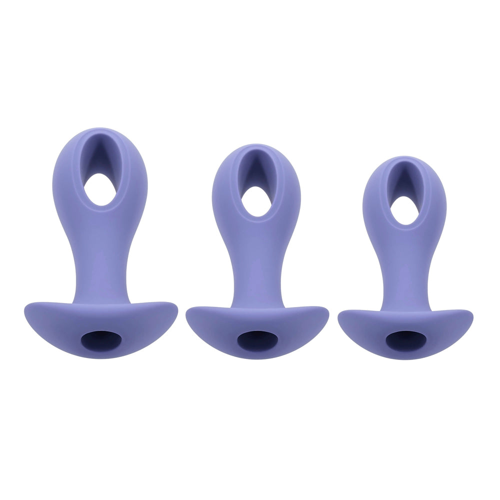 Three purple silicone anal plugs of varying sizes with a hollow center.