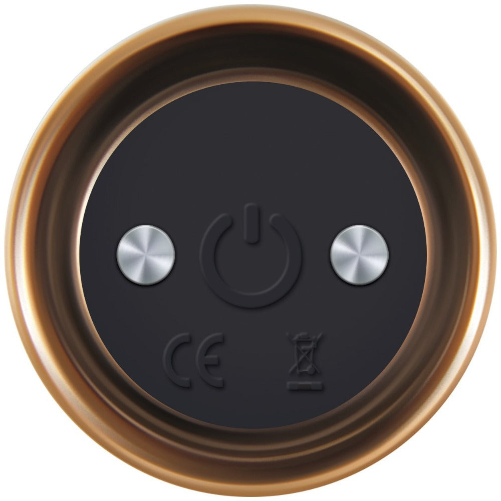 Bottom view of a bronze and black vibrating massager with power button and CE mark.