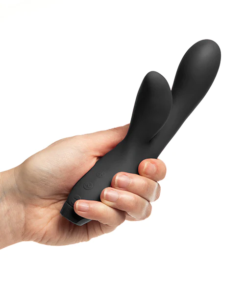 A black flexible G-spot vibrator held in a hand.
