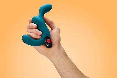 A teal vibrating prostate plug with a remote held in a hand.