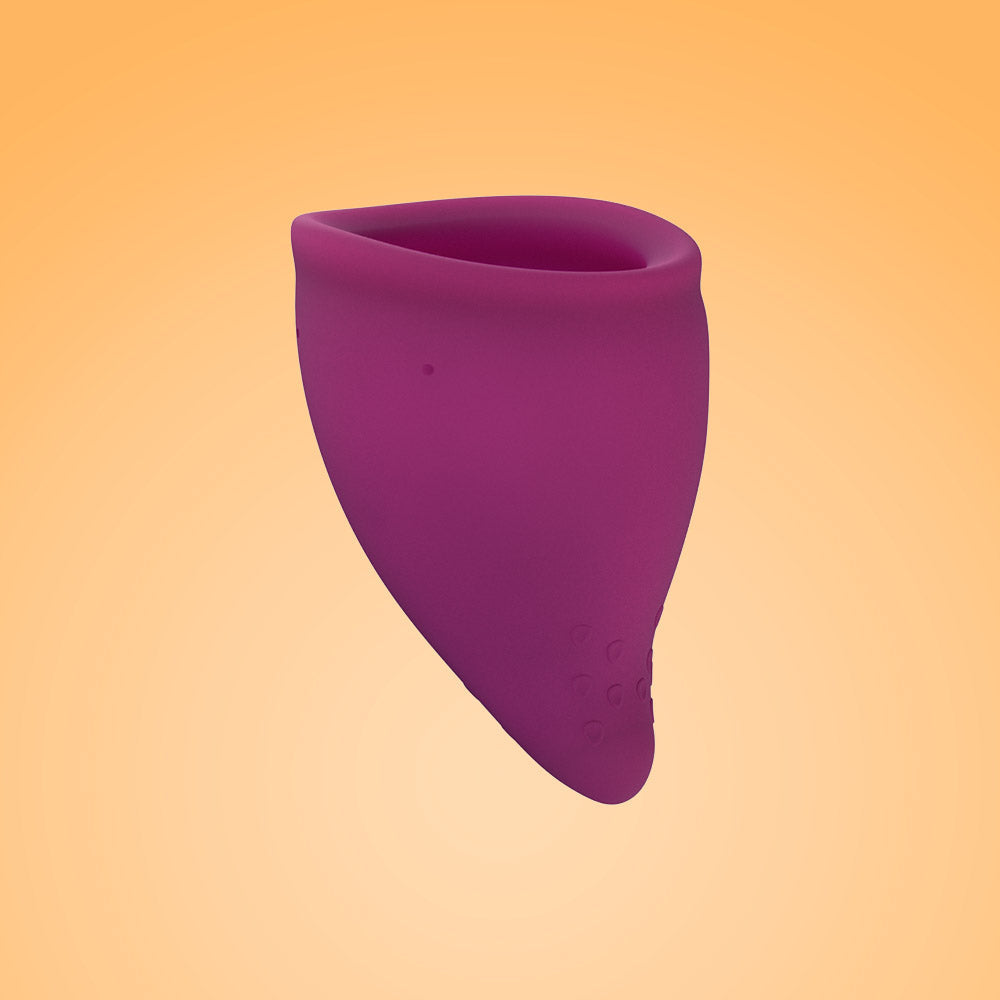 A purple reusable menstrual cup with a textured base.