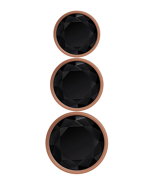 Rose gold metal anal plugs with black jewel bases in three sizes.