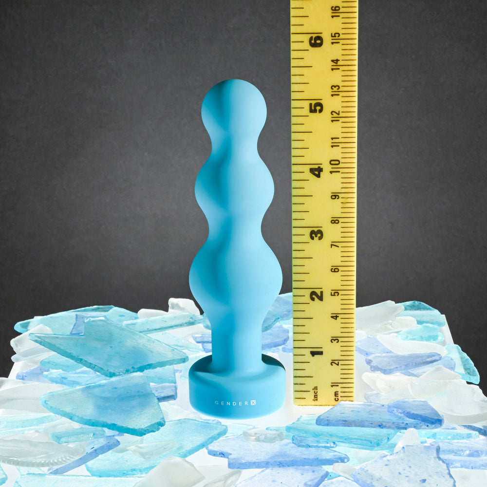 A blue beaded silicone anal plug is shown next to a ruler.