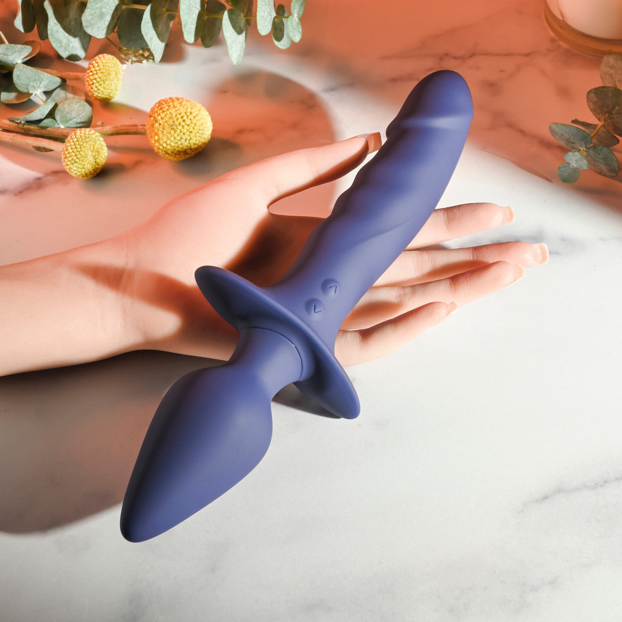 A purple dual-ended vibrator with a realistic shaft and tapered plug rests on a hand.