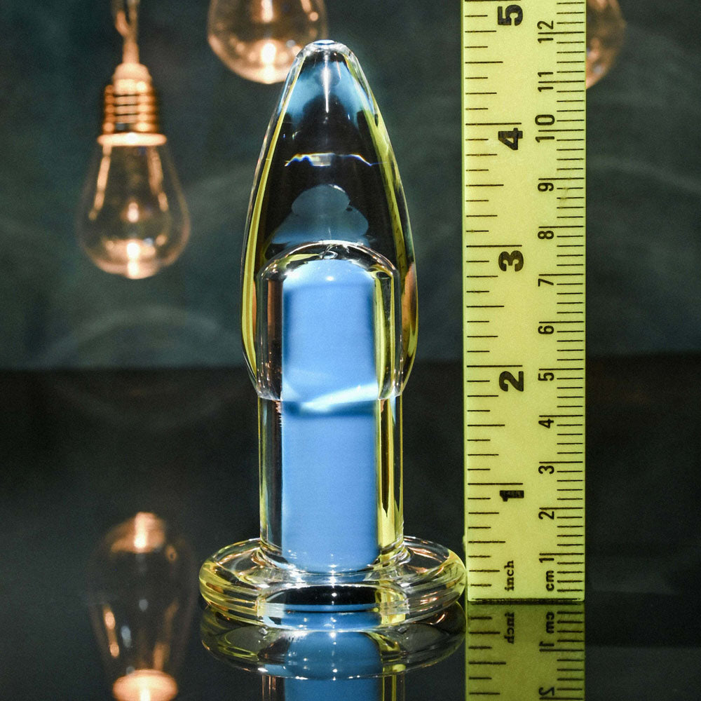 Clear glass anal plug with blue insert and ruler for scale.