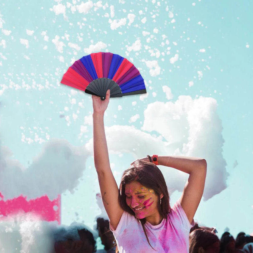 A bisexual pride hand fan with red, purple, and blue panels.