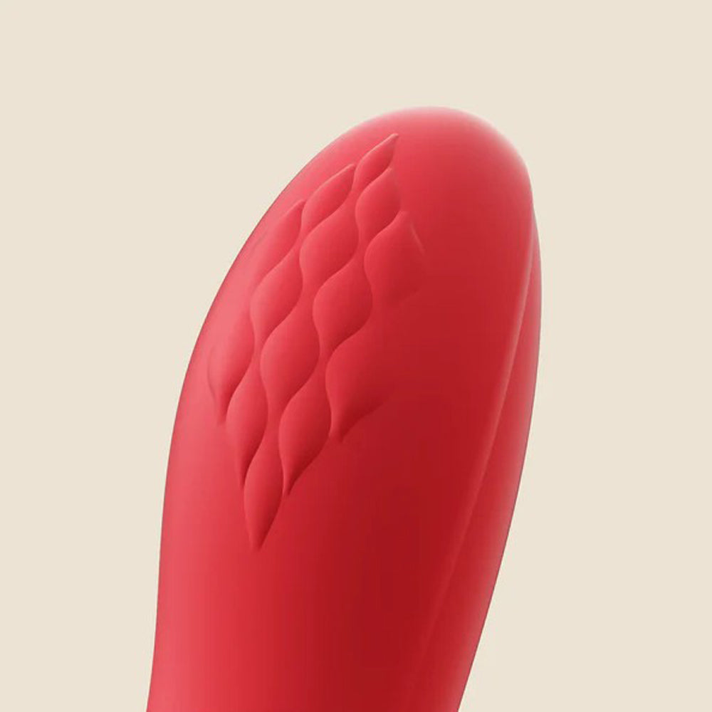 Red vibrator with textured surface and rounded tip.