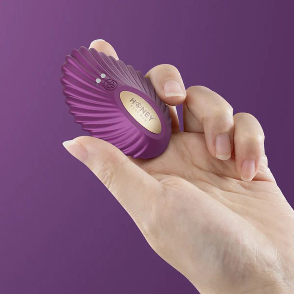 Purple app-controlled panty vibrator held in a hand.
