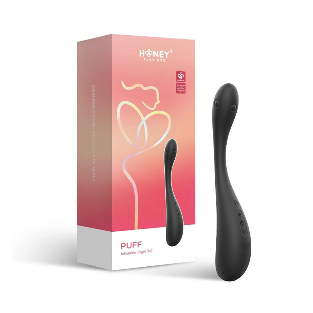 A black inflatable Kegel ball with a curved handle sits next to its pink and white box.