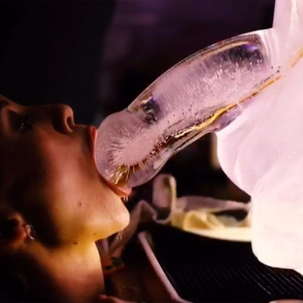 Penis-shaped ice luge mold for serving party drinks, shown frozen and in use.