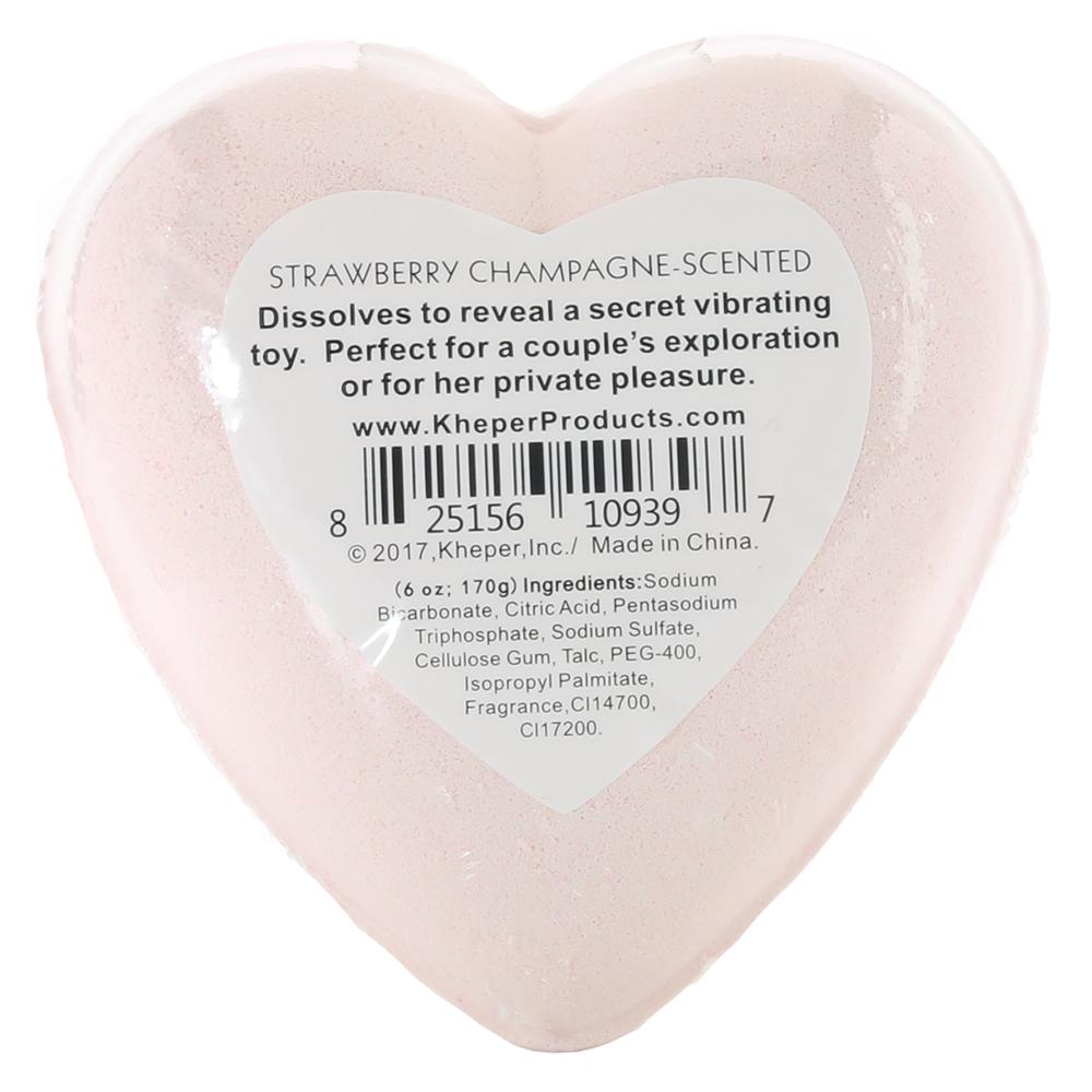 Pink heart-shaped bath bomb with "Strawberry Champagne" scent and product information.