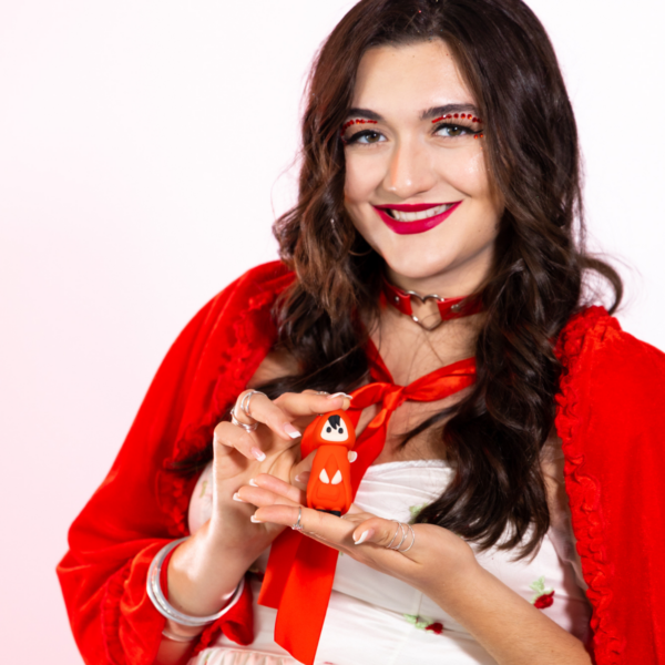 Little Red waterproof silicone bullet vibrator with a red cape and a small figurine.