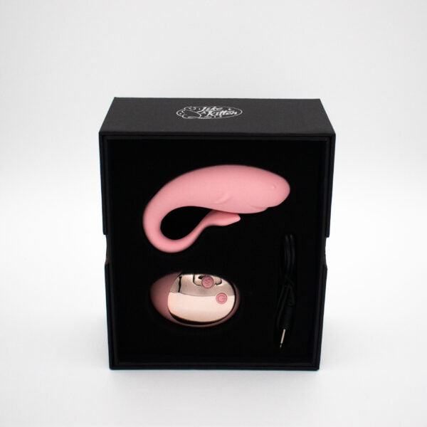 Pink whale-shaped wearable vibrator and remote in a black box.