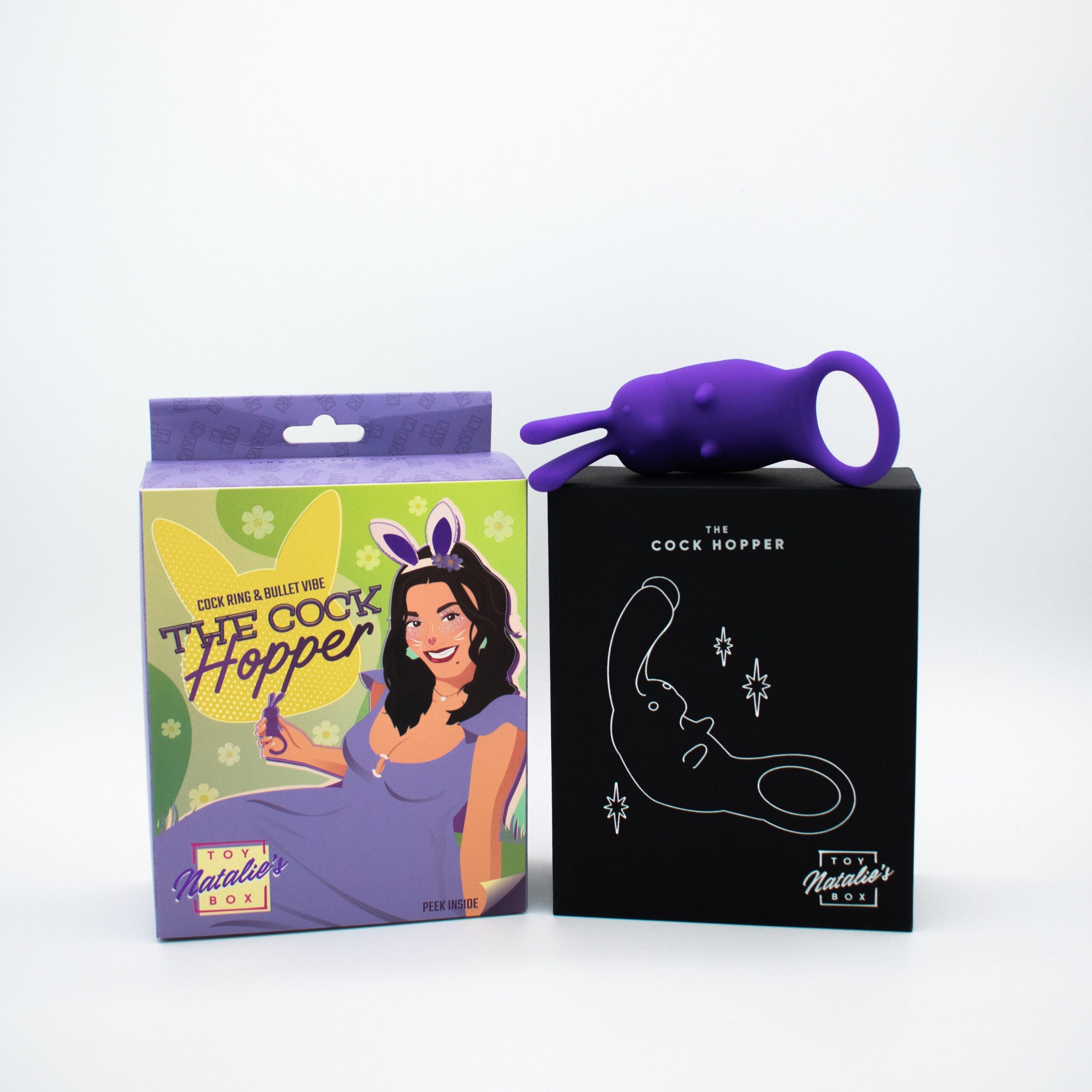 Purple rabbit-shaped cock ring and bullet vibe on black and green boxes.