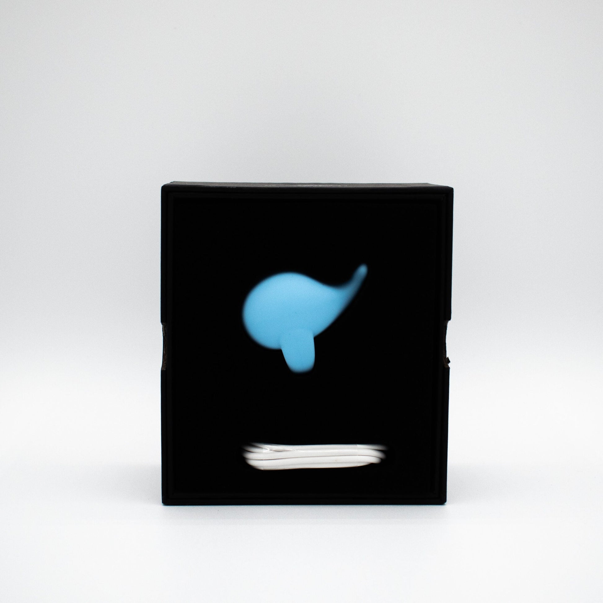 A blue whale-shaped finger vibrator in a black box.