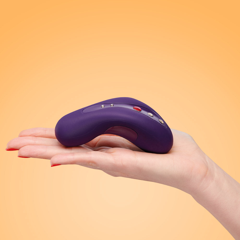 A purple curved vibrating massager rests on an open palm.