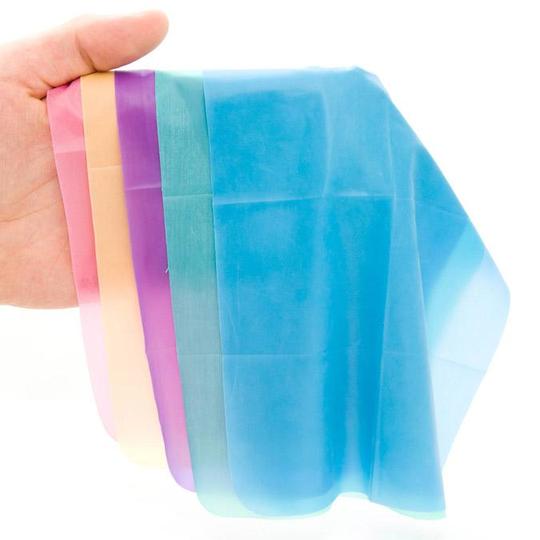 Assorted colored latex dental dams in pink, peach, purple, teal, and blue.