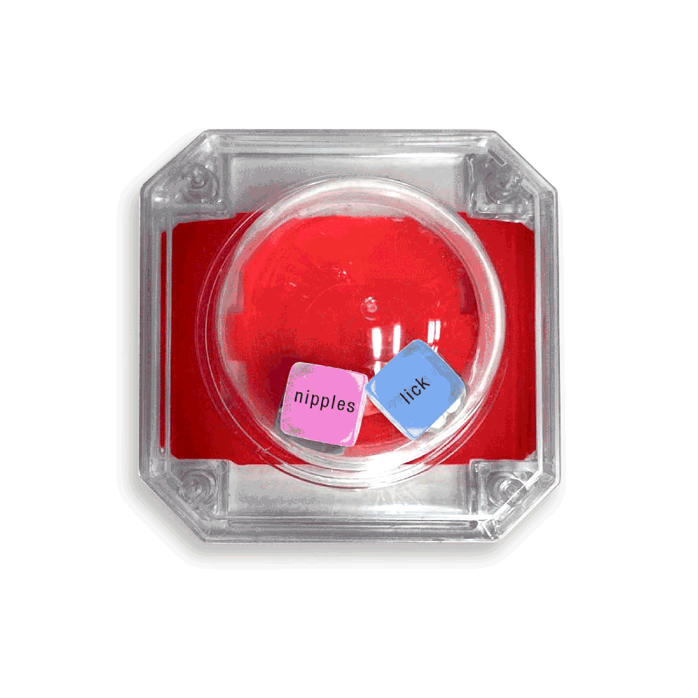 A clear plastic game with red interior, containing two dice labeled "nipples" and "lick".