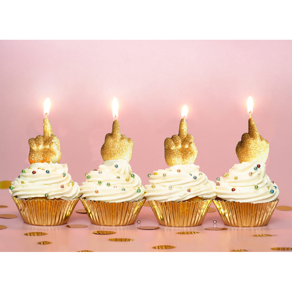 Gold glitter middle finger birthday candles on cupcakes.