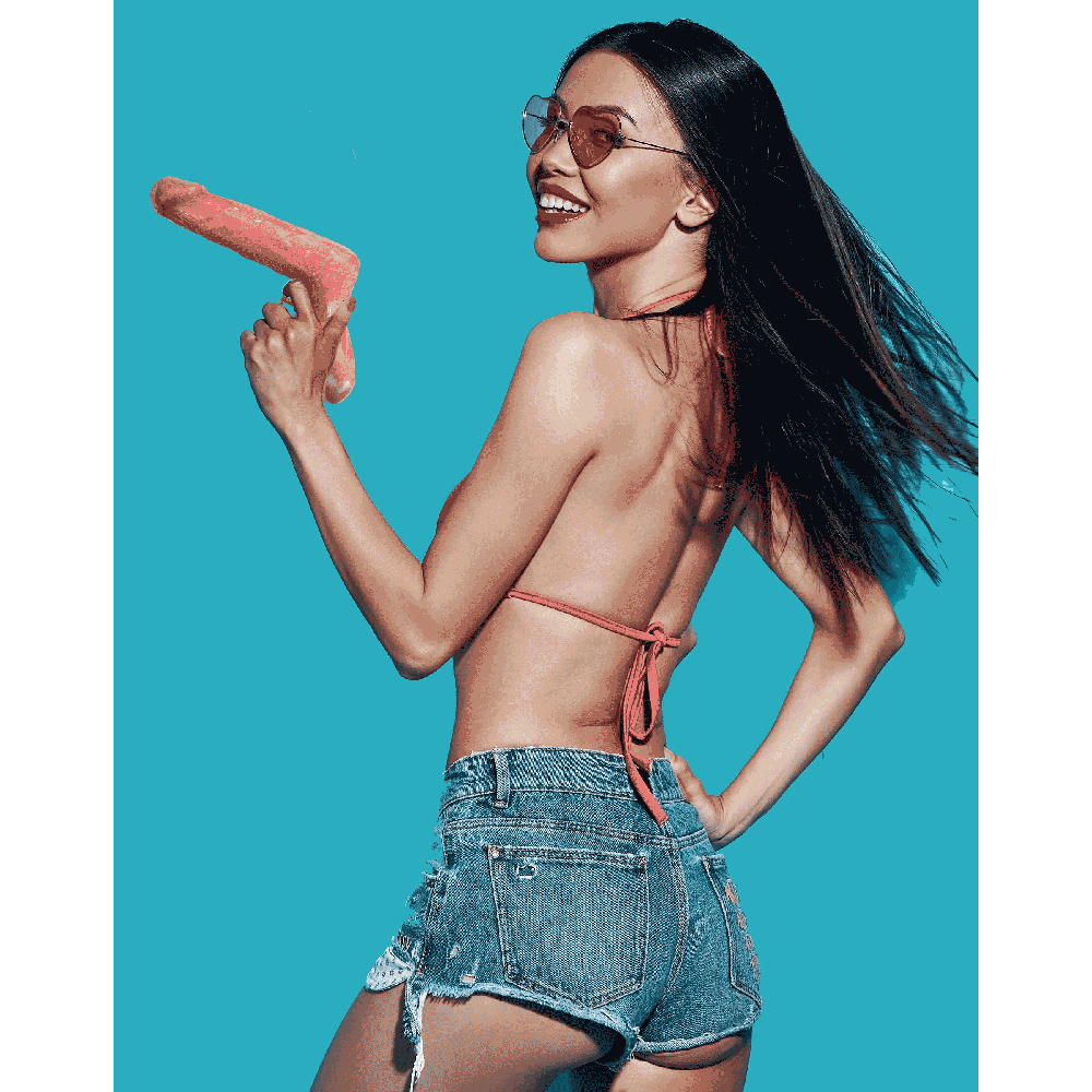 A woman in denim shorts and a bikini top holds a novelty penis-shaped squirt gun.