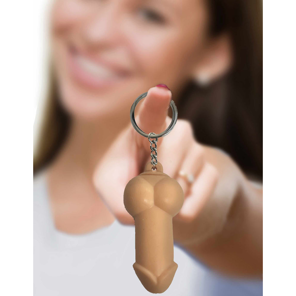 A soft silicone novelty penis keychain held by a finger.