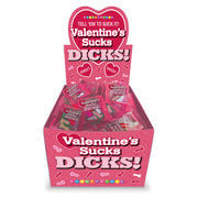 A pink display box filled with individually wrapped novelty candies that say "Valentine's Sucks Dicks".