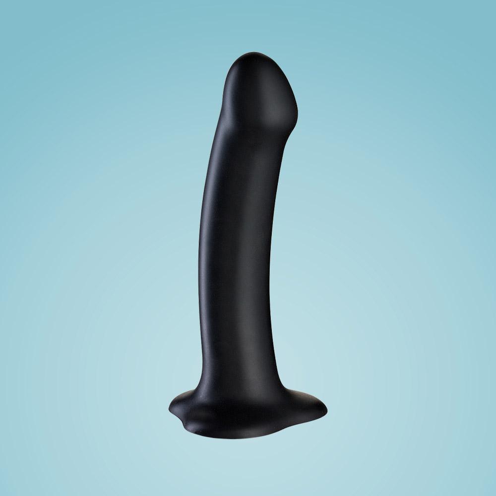 Black silicone dildo with suction base, long and curved for strap-on play.