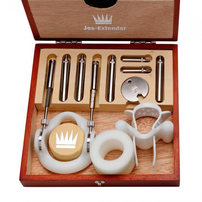 Penis extender kit in a wooden box with metal rods and white plastic components.