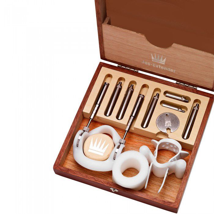 Penis extender kit in a wooden box with metal rods and white attachments.
