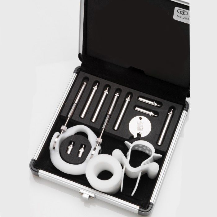 A penile extender kit with titanium rods and white plastic components in an aluminum case.