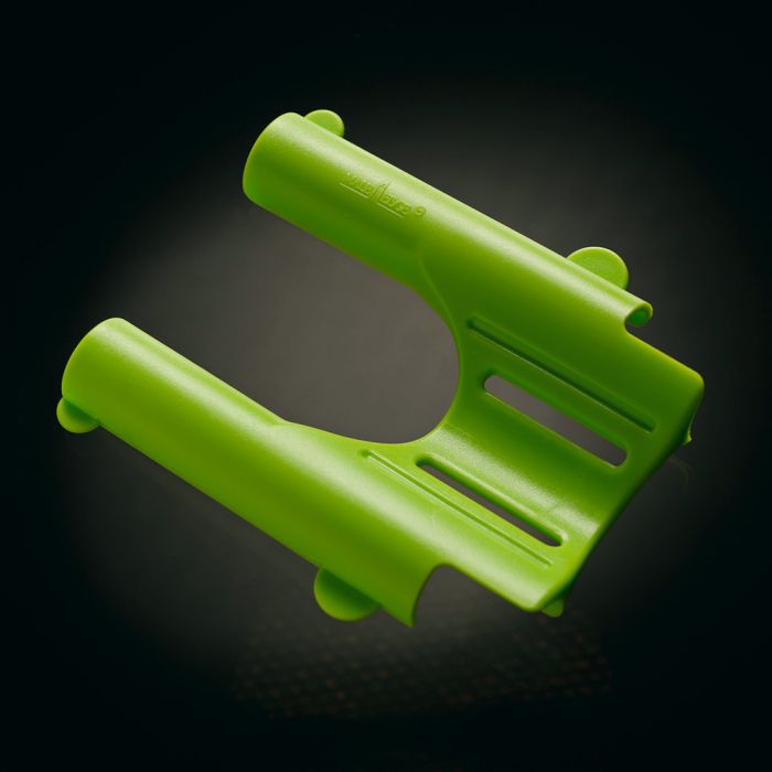 A green penis extender device with two cylindrical tubes and slotted openings.