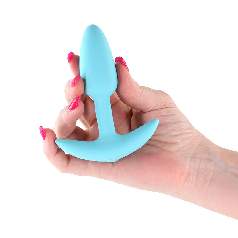 Blue silicone vibrating plug held in a hand.