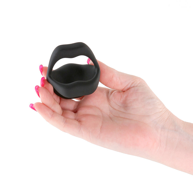 Black vibrating cock ring shaped like lips held in a hand.