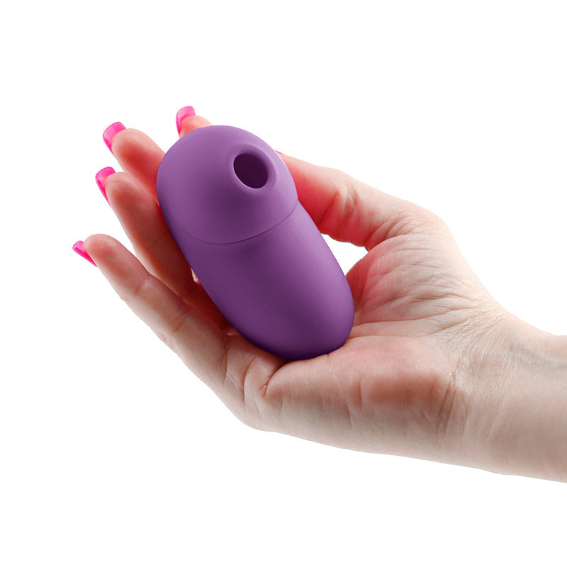 A purple silicone clitoral stimulator held in a hand.
