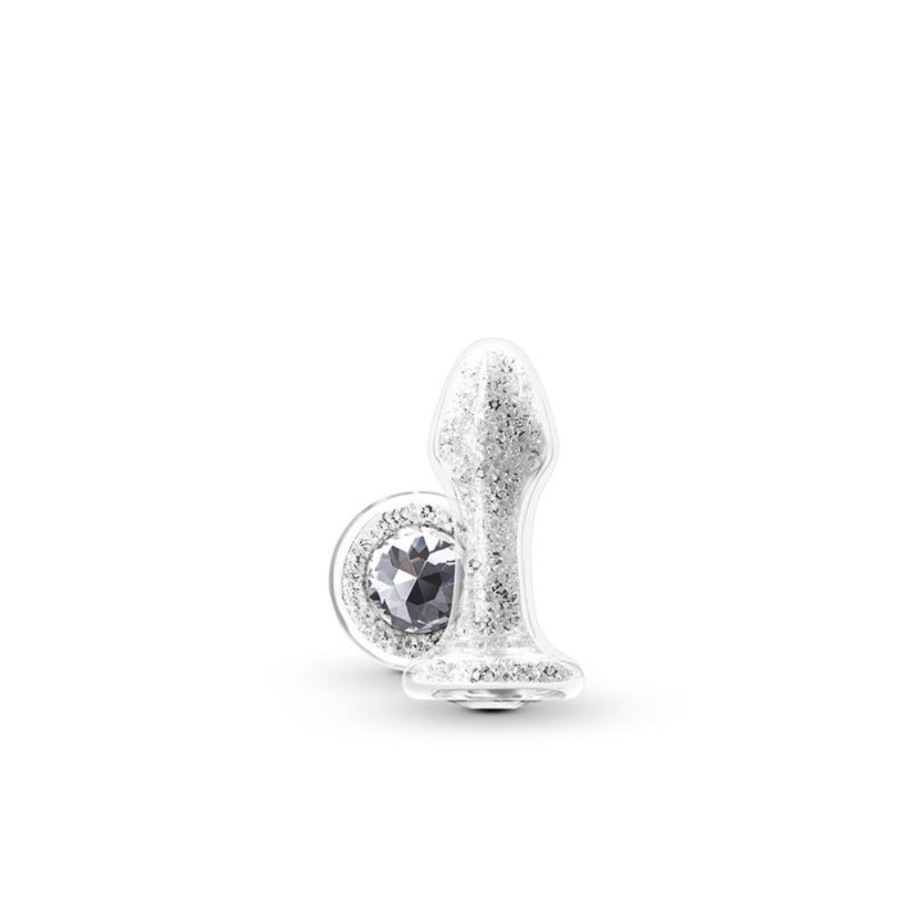 A clear glass anal plug with white crystals and a jeweled base.