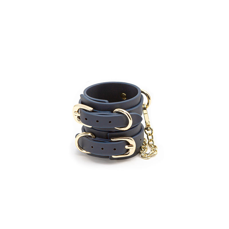 Navy blue synthetic leather wrist cuffs with gold buckles and chain.