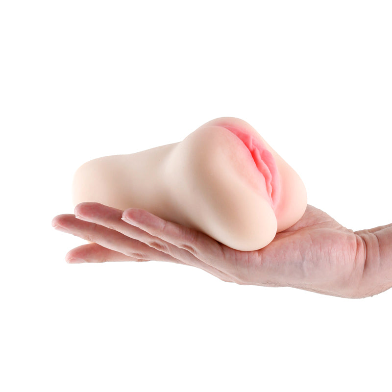 A white textured TPE male masturbator held in a hand.