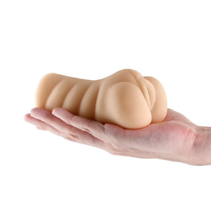 Tan textured TPE male masturbator held in a hand.