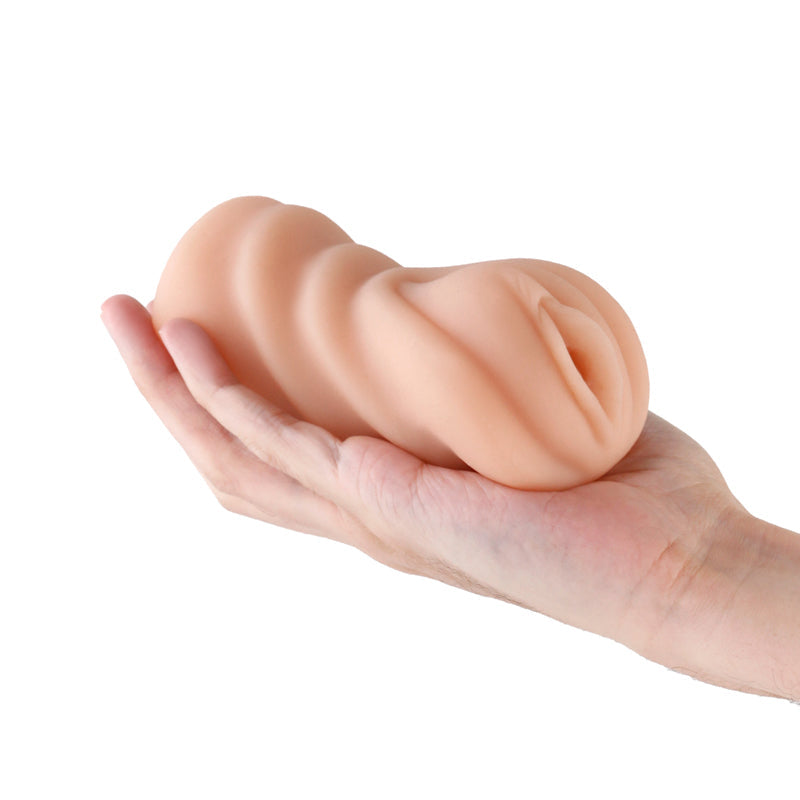 Tan realistic TPE male masturbator held in a hand.